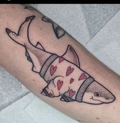 a shark tattoo with hearts on it's arm