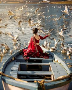 a woman in a boat surrounded by seagulls