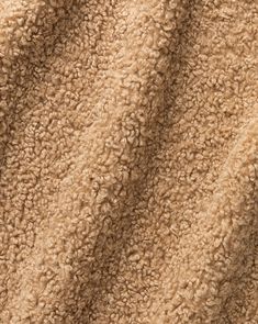 a close up view of the texture of a tan colored blanket that is soft and fluffy