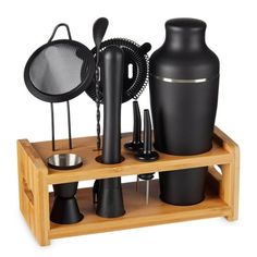 an assortment of black vases, cups and utensils on a wooden stand