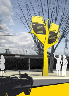 two people standing next to a yellow tree with signs on it and a car parked in front