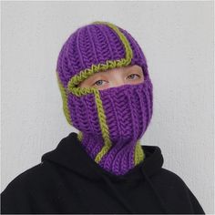 a person wearing a purple and green knitted ski mask on their face with the hood up