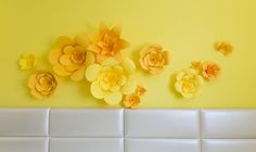 yellow paper flowers are arranged on the wall