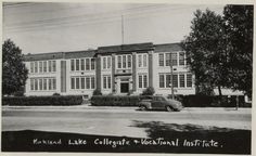 an old black and white photo of a building with cars parked in front of it