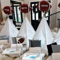 a living room filled with furniture covered in white canvass and football shaped teepeeks