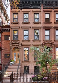 an apartment building with many windows and steps leading up to the front door, in new york city