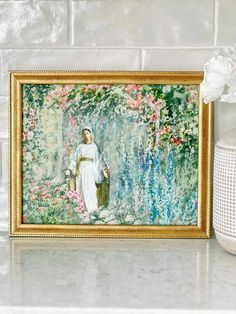 a painting on the wall next to a vase with flowers in it and a basket