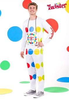 a man dressed as a clown standing in front of a wall with polka dots on it