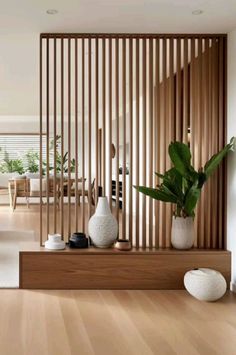 a living room with wooden slats and white vases