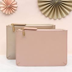 two pink and beige purses sitting next to each other