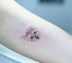 a small dog with a flower in its hair is on the leg of a woman