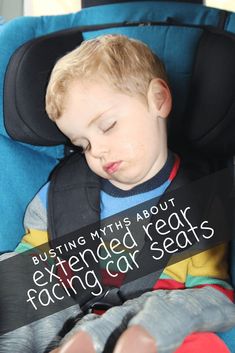 a young boy sleeping in a car seat with his head resting on a sign that reads, busting myths about extended rear facing car seats