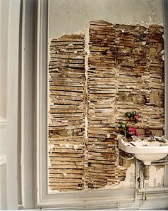 an old bathroom with a sink and wooden boards on the wall