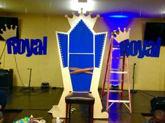 the stage is set up for an event with blue and white decorations on it, while people sit in front of them