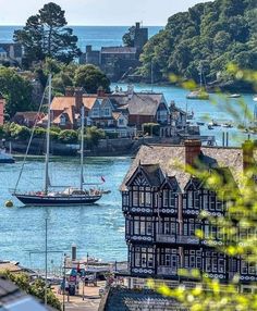 a boat is in the water next to some buildings and trees with houses around it