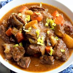 a white bowl filled with meat and vegetables