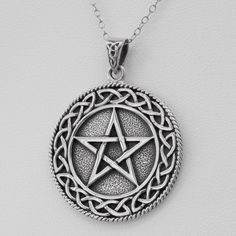 a silver pendant with an inverted pentagramil on the front, and a celtic knot around