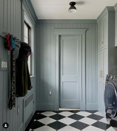 a washer and dryer are in the middle of a hallway with checkered flooring