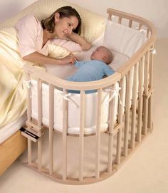 a woman holding a baby in a white crib