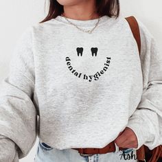 a woman wearing a sweatshirt with the words dental hygienists on it