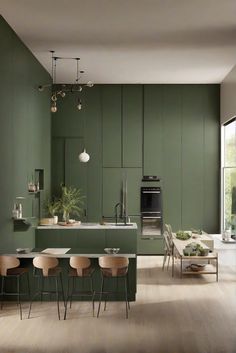 a kitchen with green walls and wooden flooring, an island table surrounded by four chairs