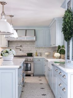 a large kitchen with white cabinets and gray counter tops, along with an island in the middle