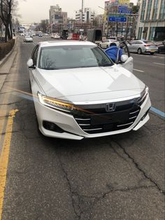 a white car is parked on the side of the road