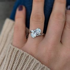 a close up of a person's hand with a diamond ring on their finger