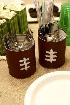 two cups with forks and spoons in them on a table