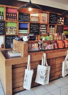 the inside of a coffee shop with bags hanging from the counter