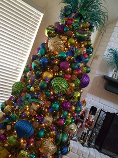 a brightly colored christmas tree is decorated with ornaments