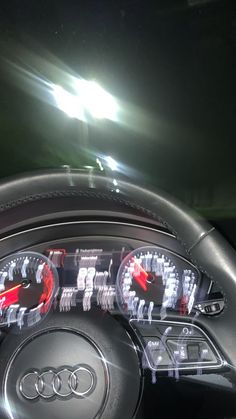 an audi car dashboard with the lights on and steering wheel illuminated by red leds