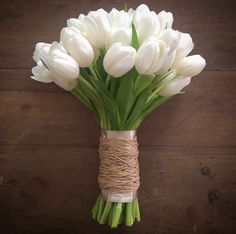 a bouquet of white tulips wrapped in twine