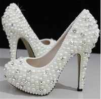 white high heeled shoes with pearls on the toes and heels are decorated with crystal stones