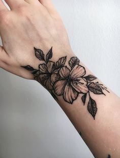 a woman's hand with a flower tattoo on it