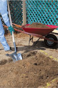 a man is shoveling dirt into a wheelbarrow