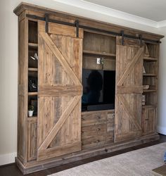 an entertainment center with sliding doors and shelves