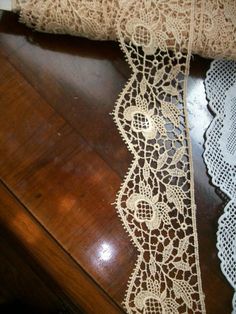 two pieces of lace sitting on top of a wooden table