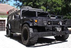 a black hummer truck parked in front of a house