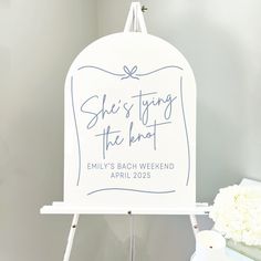 a sign that says she's tying the knot on it next to a vase with flowers