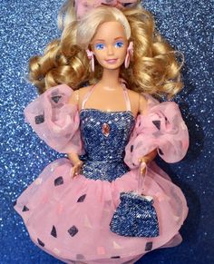 a barbie doll with blonde hair wearing a pink dress and holding a blue purse in her hand