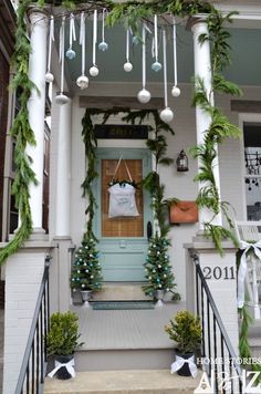 a front porch decorated for christmas with garland and ornaments