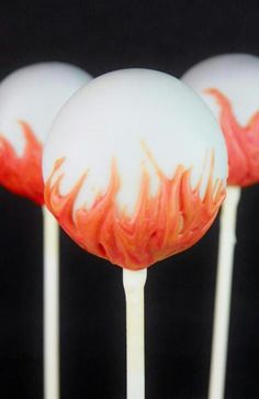 three lollipops with red and white swirl designs on them, sitting on top of each other