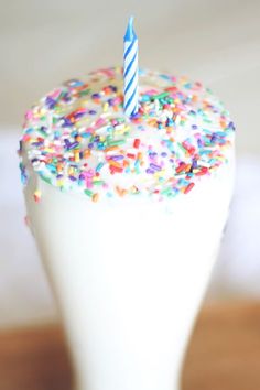 a cake with sprinkles and a candle sticking out of it's top