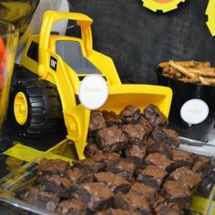 a table topped with chocolate brownies and construction truck decorations on top of each other