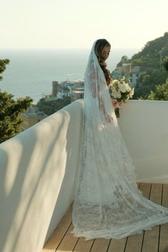 a woman in a wedding dress standing on a balcony