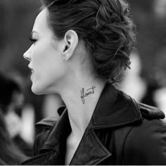 a black and white photo of a woman with a tattoo on her left side neck