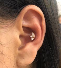 a close up of a person's ear with a diamond ring on it