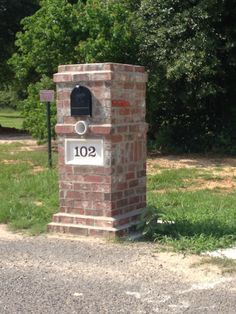 an aerial view of a brick mailbox with the number 205 on it and trees in the background