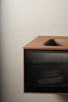 a brown microwave oven sitting on top of a counter next to a wall mounted faucet